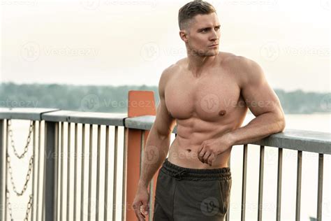 Muscular Man With Naked Torso During Fitness Workout On A Bridge