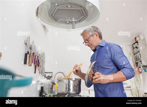 Mature Man Cooking In Kitchen Stock Photo Alamy
