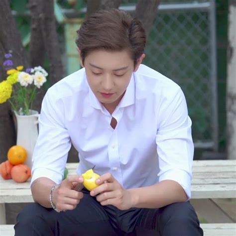 A Man Sitting On A Bench With Fruit In His Hands