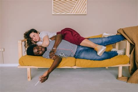 Premium Photo | Funny portrait of international couple sleeping on sofa.