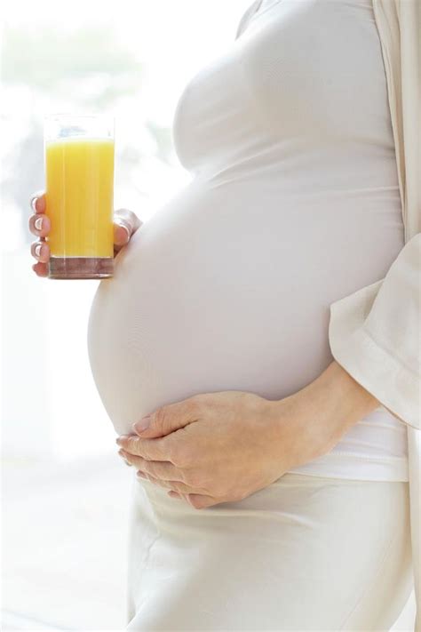 Pregnant Woman Touching Tummy With Juice By Ian Hooton Science Photo