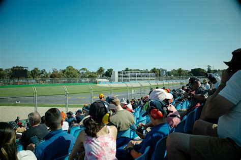 Spectators watch a race from the stands. photo – Free Woman Image on