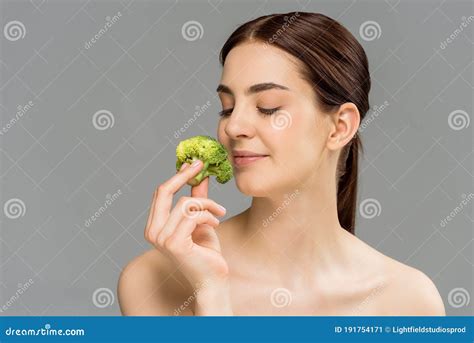 Naked Woman Smiling While Holding Green Broccoli Isolated On Grey Stock