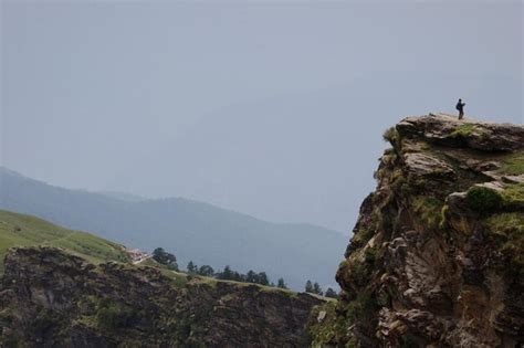 Premium Photo Man Standing On Rocky Cliff Against Clear Sky