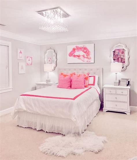 A White Bedroom With Pink Accents And Pictures On The Wall