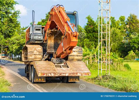 Backhoe Excavator On Truck On The Road Between Transport Stock Image