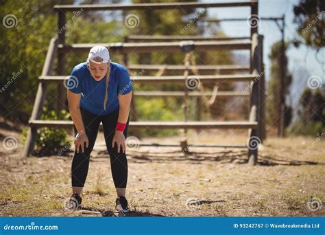 Tired Woman Bend Down With Hands On Knees During Obstacle Course Stock