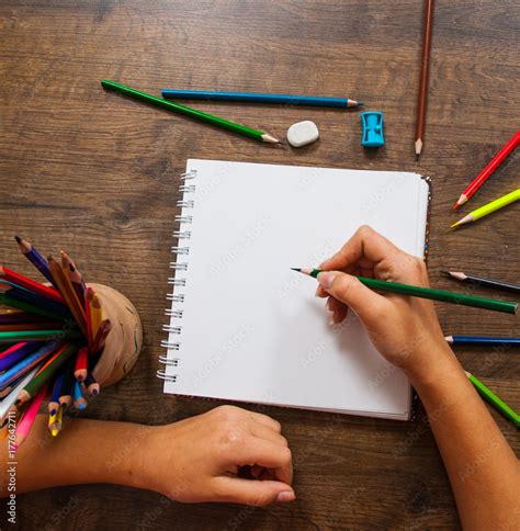 girl hand drawing, blank paper and colorful pencils on wooden table Stock Photo | Adobe Stock