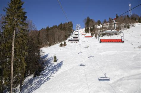 Lift Carrying Unrecognizable Skiers To The Top Of A Snow Covered