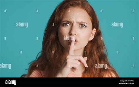 Angry Girl Seriously Showing Silence Gesture On Camera Over Colorful