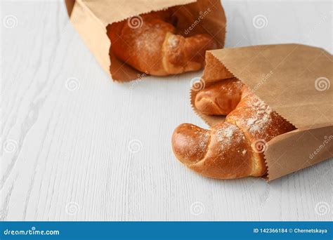 Paper Bags With Pastry On Light Wooden Background Stock Photo Image