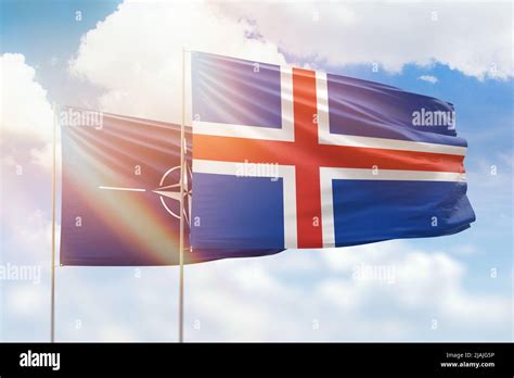 Sunny blue sky and flags of iceland and nato Stock Photo - Alamy