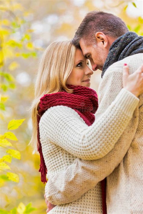 Portrait Of Mature Couple Enjoying Autumn While Showing Affection In Park Stock Photo Image Of