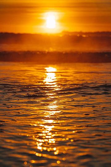 Sun Rays And Deep Blue Sky Enhance The Colorful Ocean Beach Sunrise