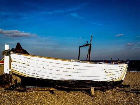 Premium Photo Abandoned Boat Moored On Field Against Blue Sky