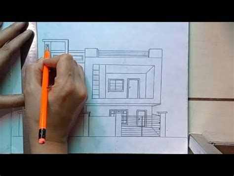 A Person Is Drawing A House On Paper