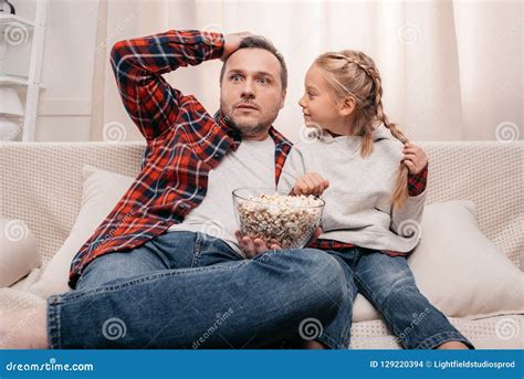 Shocked Father And Daughter Eating Popcorn And Watching Tv Together