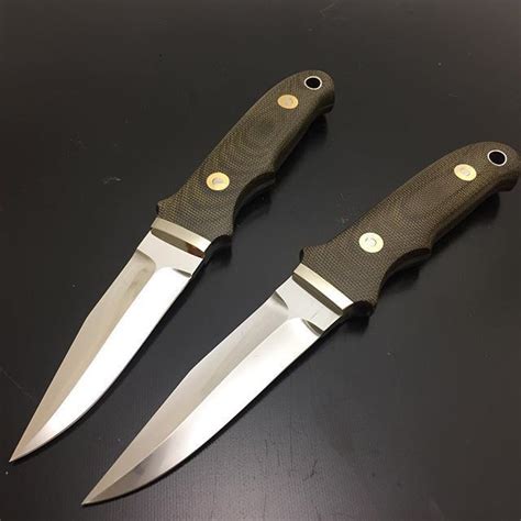 Two Knives Sitting Next To Each Other On A Table