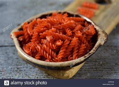 Closeup Of An Earthenware Bowl Full Of Uncooked Red Lentil Fusilli On A