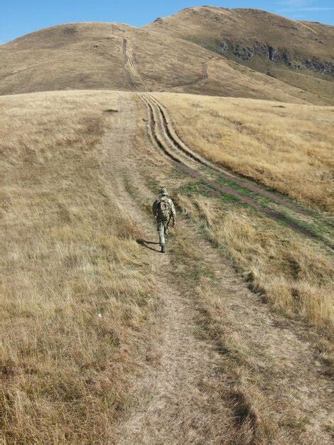 Premium Photo Rear View Of Hiker Walking Towards Mountains