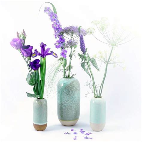 Three Vases Filled With Different Types Of Flowers