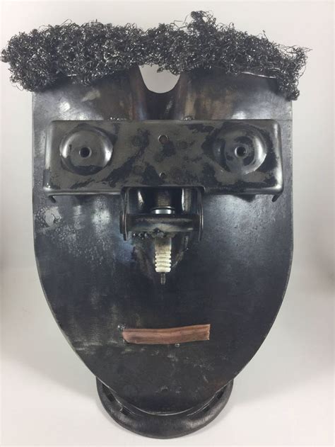 A Metal Mask With Two Eyes And Hair On It