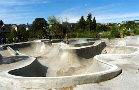 several skateboard ramps in a skate park with people on the side and ...