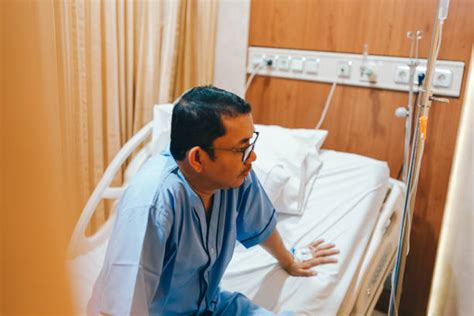 man patient  hospital room sitting   pain sad stock