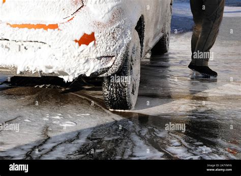 Car is cleaning with soap suds at self-service car wash. White soap suds on auto. Soapy water ...