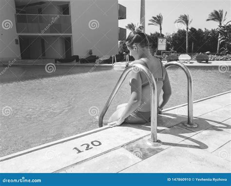 Imagen Blanco Y Negro De La Mujer Joven Hermosa En El Bikini Que Se Sienta En El Lado De La