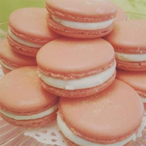 A Pile Of Pink Macaroons Sitting On Top Of A Glass Plate With White