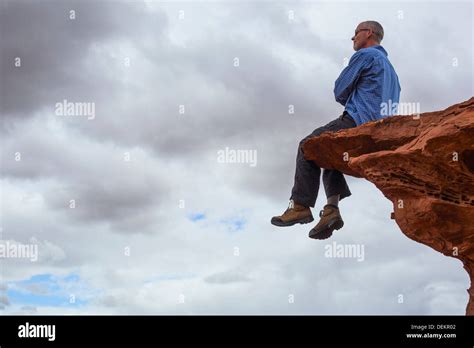 Caucasian Man Sitting On Cliff Edge Stock Photo Alamy