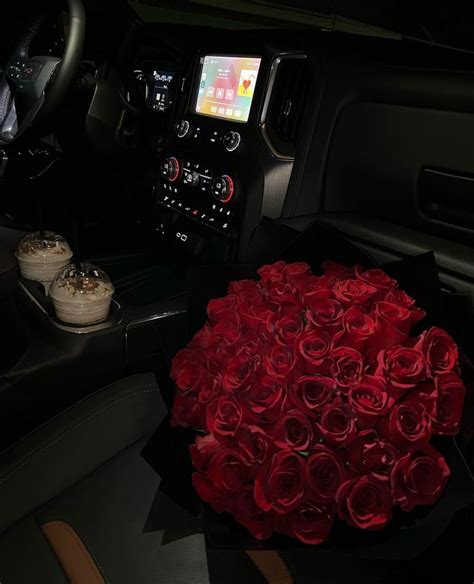 A Bouquet Of Red Roses Sits In The Center Console Of A Vehicle With An