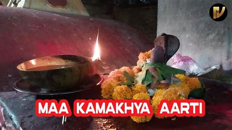 there is a bowl with flowers on it and a lit candle in the background that reads maa kakahakya aarti