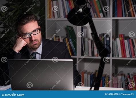 Sad And Thoughtful Businessman Watching Laptop Display At Night Stock