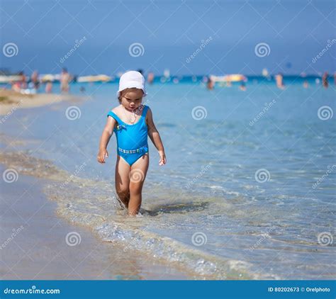 Child Girl Is Playing On Sandy Beach Near Blue Sea Stock Image Image