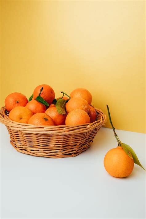 Orange Mandarins Clementine With Green Leaves In Straw Basket On A