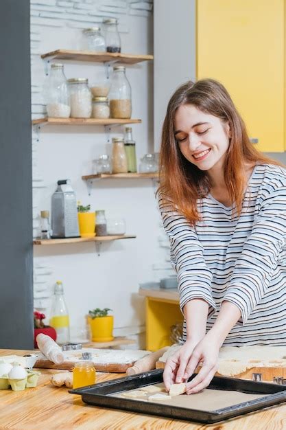 Panadería y pastelería alegre dama arreglando la masa en una sartén