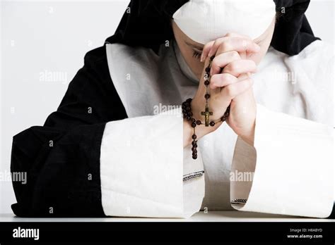 Nun praying the rosary Stock Photo - Alamy