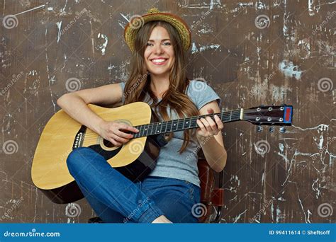 Happy Young Woman with Hat Sitting with Acoustic Guitar on Grunge Wall ...