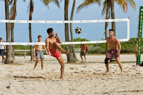 Young Men Kick A Soccer Ball On Beach Volleyball Court — Stock ...