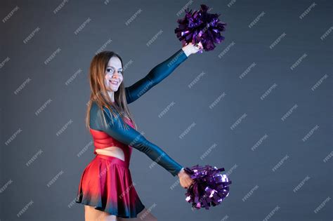 Premium Photo Happy Cheerleader Girl In Uniform Dancing With Pompoms Isolated On Grey Background