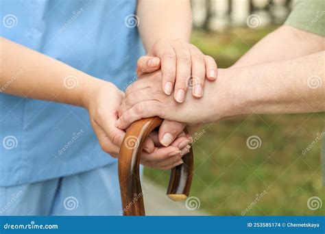 Elderly Woman With Walking Cane And Female Caregiver Outdoors Closeup