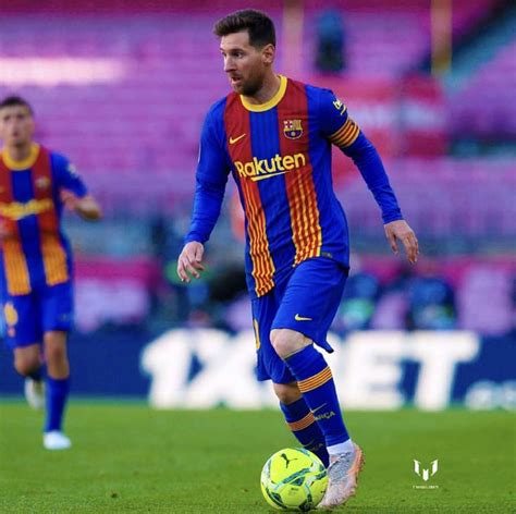 A Man In Blue And Red Uniform Playing Soccer On Field With Other