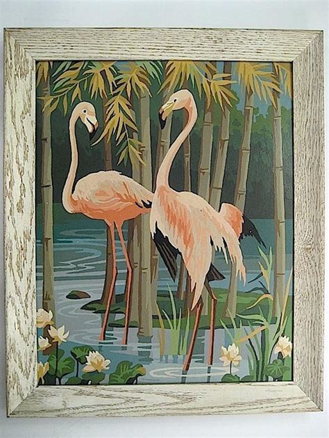 Two Pink Flamingos Standing In The Water Surrounded By Bamboo Trees And