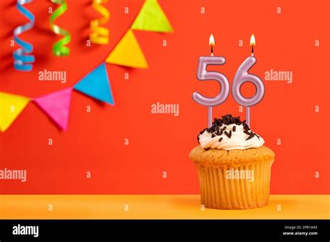 Birthday cake with number 56 candle - Sparkling orange background with ...