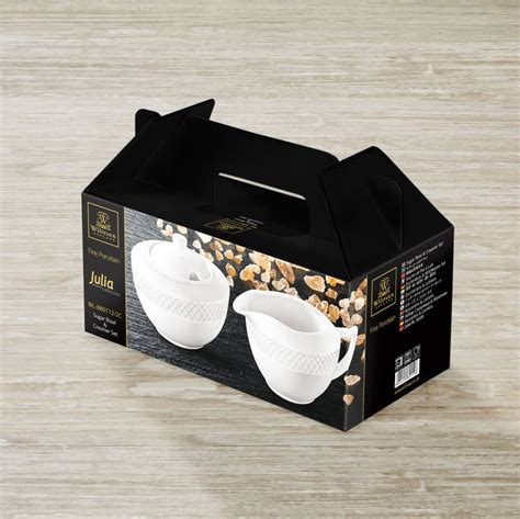 An Empty Box With Two White Cups In It Sitting On A Table Next To Some Nuts