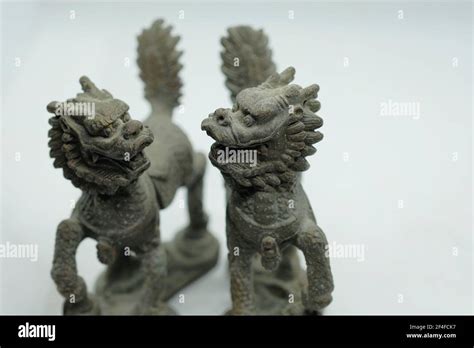 A pair of mythical Chinese bronze Qilin figurines, with head of a dragon, antlers of a deer ...