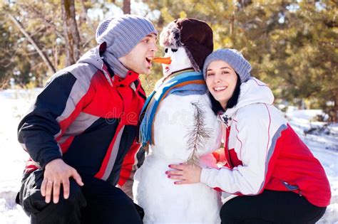 Couple with a snowman stock photo. Image of relations - 21993964