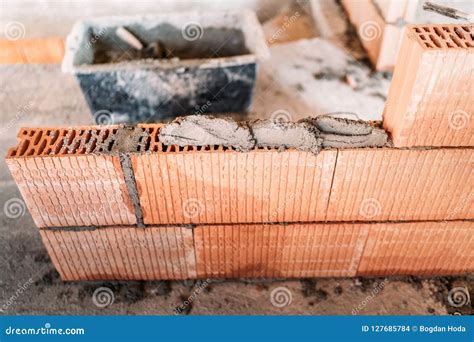 Details Of Worker Bricklayer Placing And Adjusting Bricks